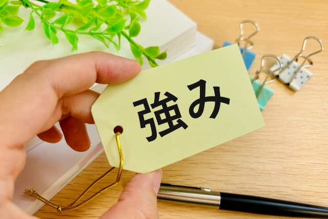 強みと書かれた紙を持つ手