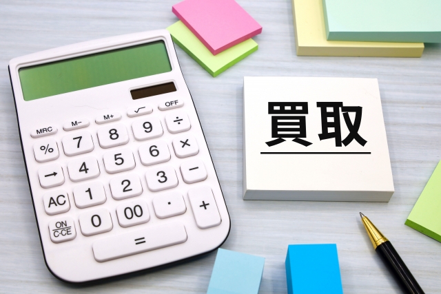 買取と書かれた付箋と電卓