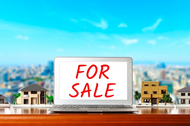 FOR SALEの文字が表示されたパソコンと家の模型